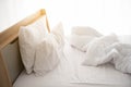 White unmade bed in the morning with sunshine with white curtain background in elegant home. Interior design and luxury furniture Royalty Free Stock Photo