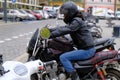 White urban scooter and defocused woman on a powerful black motorcycle in a parking in the tourist center of the city. Scooter