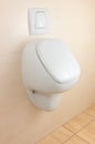 White urinal on beige tiled wall