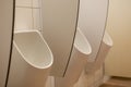 white ceramic urinal in mens bathroom in restaurant toilette