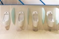 White urinal with a row of automatic pouring sensors and a stopper