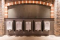 White urinal with rows of automatic pouring sensors and barriers in a modern supermarket