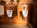 White urinals in teak wood wall, Bath room