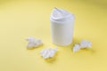 A white urn and crumpled paper on a light yellow background