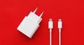White USB- C Power Adapter and Two USB- C Cables on a Red Background type c usb-c Royalty Free Stock Photo