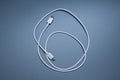 White USB cable for charging and data transfer coiled on blue background Royalty Free Stock Photo