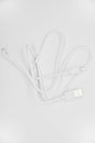 White USB cable for charging the phone on a white background. White cord for charging gadgets Royalty Free Stock Photo