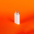 White USB euro plug wall charger adapter for mobile phone on orange background Royalty Free Stock Photo