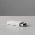 White USB flash drive on a light gray wooden surface. The rectangular device has a Royalty Free Stock Photo