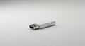 A white USB flash drive is positioned against a plain, light gray background. The Royalty Free Stock Photo