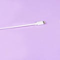 White usb mobile phone charging cable on purple background Royalty Free Stock Photo