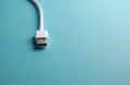 White USB Type C cable end lies on bright blue surface. Connect device for data transfer or power charge. Modern tech accessory Royalty Free Stock Photo