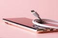 White USB Type-C connector next to a modern mobile phone - smartphone on a pink background. Recharging mobile gadgets. Shallow Royalty Free Stock Photo