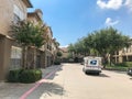 White USPS truck stops at apartment building complex on sunny da