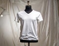 White V Neck T Shirt on a Mannequin Display with a Soft Focus Background Royalty Free Stock Photo