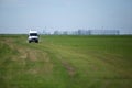 White van drive alone on a grass field on a sunny summer day