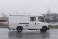 White van drives down the street in the rain Royalty Free Stock Photo