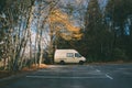 White van parked in the parking lot surrounded by beautiful green trees Royalty Free Stock Photo