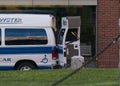 White van parked on a street in an urban setting, its side door open