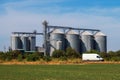 White van passing by agricultural farm silos for grain storage Royalty Free Stock Photo