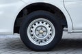 White van wheel with a steel rim, parked on a paved surface Royalty Free Stock Photo