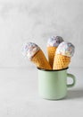 White vanilla ice cream scoop in waffle cone with sprinkles in cup on light grey background Royalty Free Stock Photo