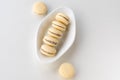 White vanilla macaroons on wooden background. Delicious Argentinian cookies alfajores with cream on plate. Top view.