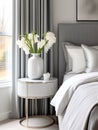 White vase with flowers on round nightstand near bed. Art deco style interior design of modern bedroom. Created with generative AI