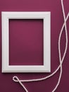 White vertical art frame and pearl jewellery on purple background as flatlay design, artwork print or photo album