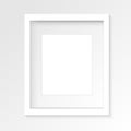 White vertical photo frame on gray wall with realistic shadows.