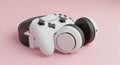White Video Game Controller and Headphones on a Pink Background Royalty Free Stock Photo
