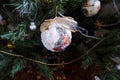 White vintage ball with fabric bow hanging on Christmas tree across other decorations close-up. Christmas decoration on a tree. Ho Royalty Free Stock Photo