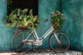 White vintage bike with basket full of flowers next to an old building in Danang, Vietnam, close up Royalty Free Stock Photo
