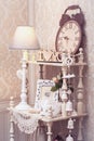 White vintage bookcase with wooden clock and lamp