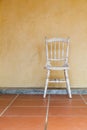 White Vintage chair near yellow old wall Royalty Free Stock Photo