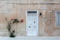 White vintage door in medieval building with red Bougainvillea branch Royalty Free Stock Photo