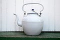 A white vintage enamel kettle on a white background