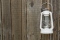 White vintage handle gas lantern on rustic wooden wall. Royalty Free Stock Photo