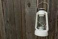 White vintage handle gas lantern on rustic wooden wall. Royalty Free Stock Photo