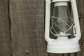 White vintage handle gas lantern on rustic wooden wall. Royalty Free Stock Photo