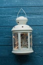 White vintage Lantern with burning candles, pine cones on wooden table and glitter lights background. Christmas background. happy Royalty Free Stock Photo