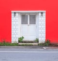 White vintage retro wooden door on red wall background. Home interior architecture design, plain tropical textured wood panel Royalty Free Stock Photo