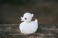 White vintage toy duck on wooden bench