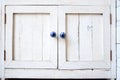 White vintage wooden cupboard with blue knobs