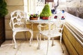 White vintage wrought iron gardening furniture, set of empty round table and two elegant chairs on balcony. Royalty Free Stock Photo
