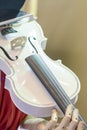 White violin in the hands of a robot. The robot playing the violin. vertical photo