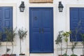 White wall with blue painted wooden door and shuttered windows in Mediterranean town Royalty Free Stock Photo