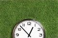 white wall clock on turf green grass background Royalty Free Stock Photo