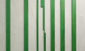 white wall with green vertical stripes, creating rhythmic pattern. Royalty Free Stock Photo