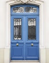White wall of the house with a closed blue wooden door in Paris, France Royalty Free Stock Photo